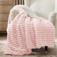 a white chair with a pink blanket on it