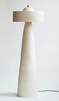 a white table lamp with a beige shade on it