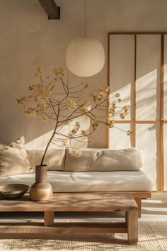 a living room with a couch, coffee table and vase on the floor in front of it