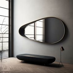 a black bench sitting in front of a large mirror on the side of a wall