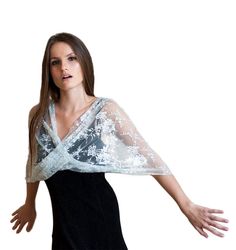 Step into the realm of timeless elegance with our Silver Lace Loop Shawl - a captivating and lightweight accessory that elevates your look in four different ways: as a shrug, shawl, crisscrossed shawl, or scarf. The exquisite silver hue exudes sophistication and glamour, making it a perfect choice for special occasions and refined events. Available in three sizes for a flawless fit: Petite (US 0-6) One size (US 8-14) Plus size (US 14-22) This exquisite shawl comes with wearing instructions, beautifully presented in a printed gift bag, making it a thoughtful and charming gift option for your loved ones. Additionally, we've thoughtfully included a QR code linked to the movie clip, granting you easy access to styling ideas. Experience the elegance in our YouTube clip: http://www.youtube.com/w Balochi Dress, Lace Bolero, Bridal Shawl, Gala Events, Lace Wrap, Wrap Shawl, Lace Shawl, Movie Clip, Shawls And Wraps