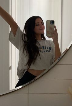 a woman taking a selfie in front of a mirror