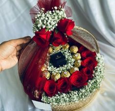 a basket filled with red roses and chocolates