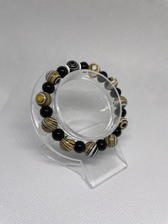 This Handmade Unisex Bracelet Features 1 Unique Evil Eye. It includes 10 beads @ 10mm with a fun Tiger theme. It is accompanied by 11 Black Gloss 8mm beads. There is no closure. This Bracelet is Double Strung on Clear Elastic .5mm Stretch Magic String. Gently Glide on and off your wrist and ENJOY 😊 Cheap Handmade Black Evil Eye Bracelet, Evil Eye Black Bracelet, Black Adjustable Evil Eye Bracelet, Adjustable Hand-strung Black Evil Eye Bracelet, Bohemian Adjustable Hand-strung Evil Eye Bracelet, Holiday Bracelets, Hamsa Bracelet, Hippie Bracelets, Unisex Bracelets