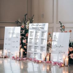 wedding seating chart displayed on table with candles and flowers in the back drop off area