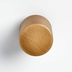 a close up of a knob on a white surface with a light brown color in the background