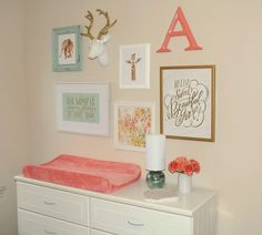 a white dresser topped with lots of drawers and framed pictures on the wall above it