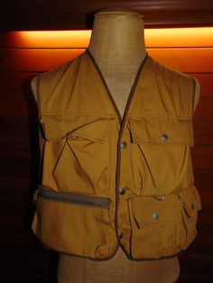 a mannequin wearing a yellow vest with zippers on the front and side