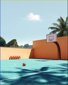 an outdoor basketball court with chairs and a basket ball on the ground in front of it