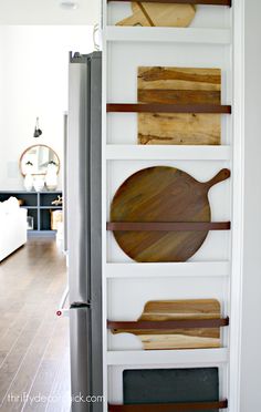 wooden cutting boards mounted to the side of a refrigerator