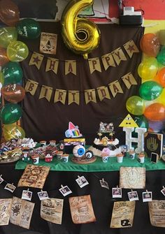 a table topped with lots of different types of items and balloons in the shape of numbers