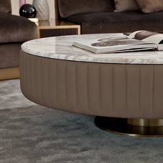 a round coffee table with a magazine on top