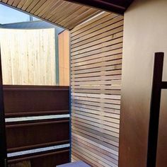 a bathroom with wooden slatted walls and a bench in the corner next to it