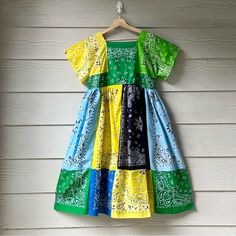 a colorful dress hanging on a wall with wood planks in the backround