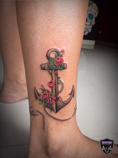 an anchor with roses on the side of its leg is shown in this tattoo design