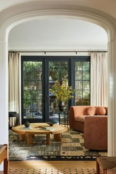 a living room with two couches and a coffee table in front of an arched doorway