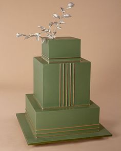 a three tiered green cake with silver flowers on top