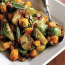 a white plate topped with brussel sprouts and squash