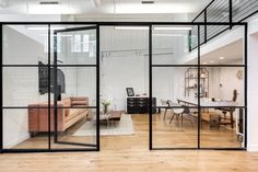 an office with glass walls and wooden floors