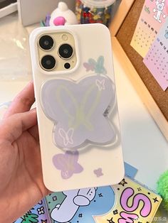 a person holding up a phone case with a sticker on it