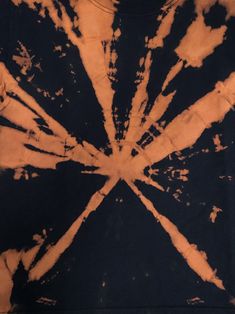 an orange and black tie - dye t - shirt with the sun shining through it