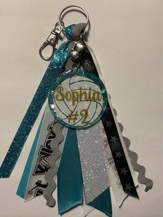 a keychain that has some type of ribbon attached to it with the word sophin on it