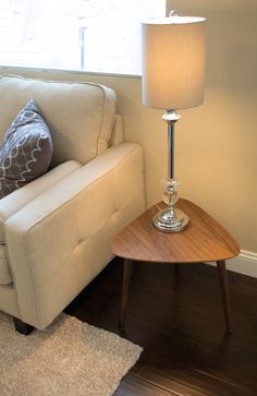 a living room with a couch, table and lamp