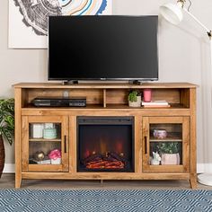 an entertainment center with a fireplace and television on it's stand in front of a painting