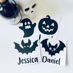 three halloween stickers with bats and pumpkins on them next to a bottle of booze