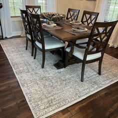 a dining room table with chairs and plates on it