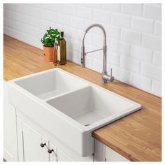 a white kitchen sink sitting on top of a wooden counter