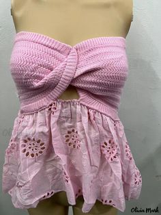 a mannequin wearing a pink top with cut outs and crochet on the bottom