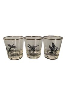 three glasses with birds on them sitting next to each other