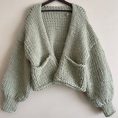 a sweater hanging on a hanger with the back turned to look like it has been knitted