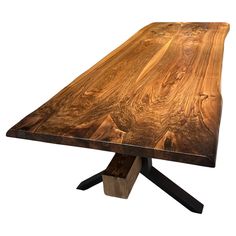 a wooden table with two black legs and a wood slab on the top that is shaped like an x