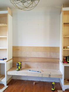 an unfinished room with shelves and tools on the floor