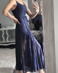 a woman in a blue dress taking a selfie