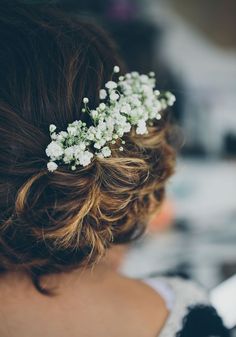 a close up of a woman with flowers in her hair