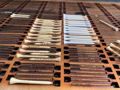 several different types of toothbrushes are lined up on a wooden table with holes in them