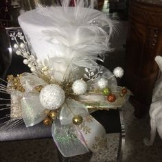 a white hat with feathers and ornaments on it's headband, sitting on a chair