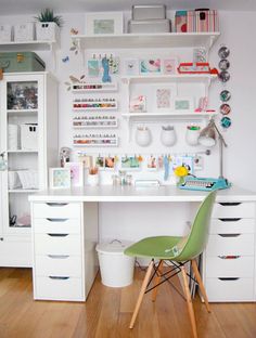 a white desk topped with lots of drawers next to a shelf filled with craft supplies