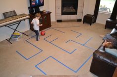 a kid playing with a ball in a living room next to a piano and tv