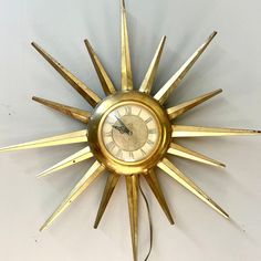 a gold clock that is hanging on the wall