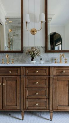 a bathroom with double sinks and two mirrors