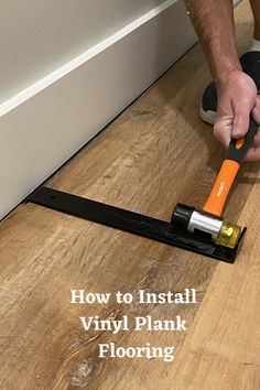 a man is using a pair of scissors to cut vinyl planks on the floor