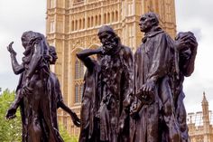 three bronze statues in front of the big ben clock tower