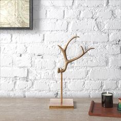 a deer antler on a wooden table next to a candle holder and some other items