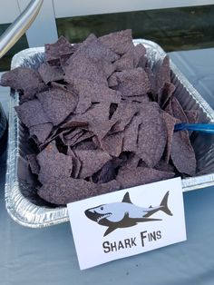 a tray filled with chips next to a sign that says shark fins on the side