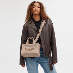 Carry as much (or as little) as you like with our lightweight Cargo tote. Detailed with our cursive Coach script embroidery and iconic turnlock closure this compact 26 has an open interior with room for an iPad two outside pockets for easy organization and a removable webbing strap for shoulder or crossbody wear. Crafted to last this versatile carryall is made with cotton sourced from farms that use regenerative agricultural practices* and inspired by our commitment to reducing our impact on the Natural Gift Wrapping, Script Embroidery, Fancy Things, Agricultural Practices, Cute Wallets, Webbing Strap, Easy Organization, Pretty Bags, Recycled Leather