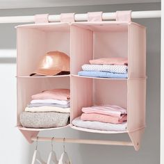 a pink shelf with clothes and hats on it